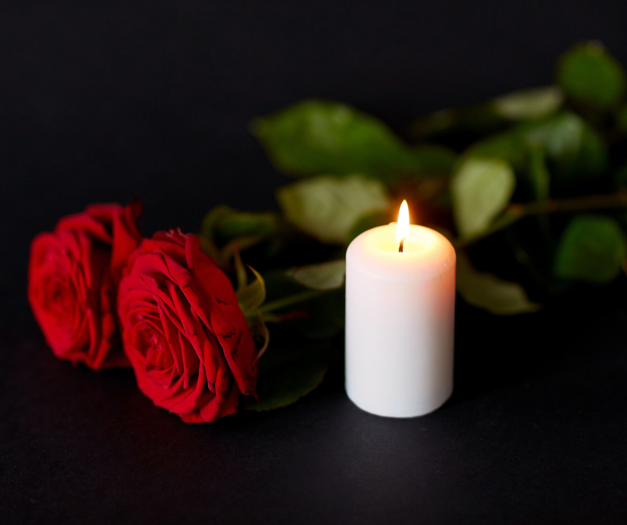 Odszedł śp. Henryk Kamiński radny Rady Powiatu w Nysie Zdjęcie przedstawia dwie róże i świeczki